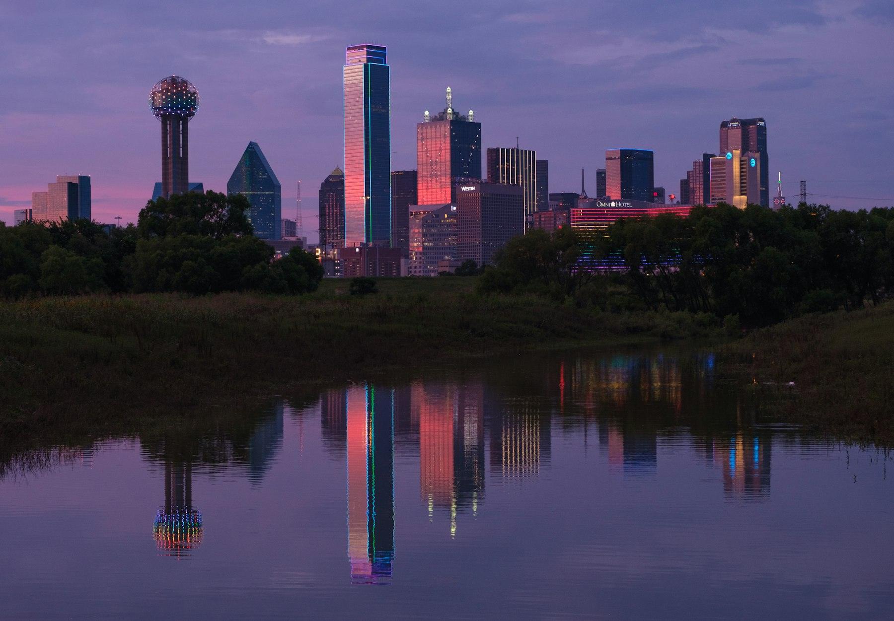 The Dallas skyline at dusk reflected in still water