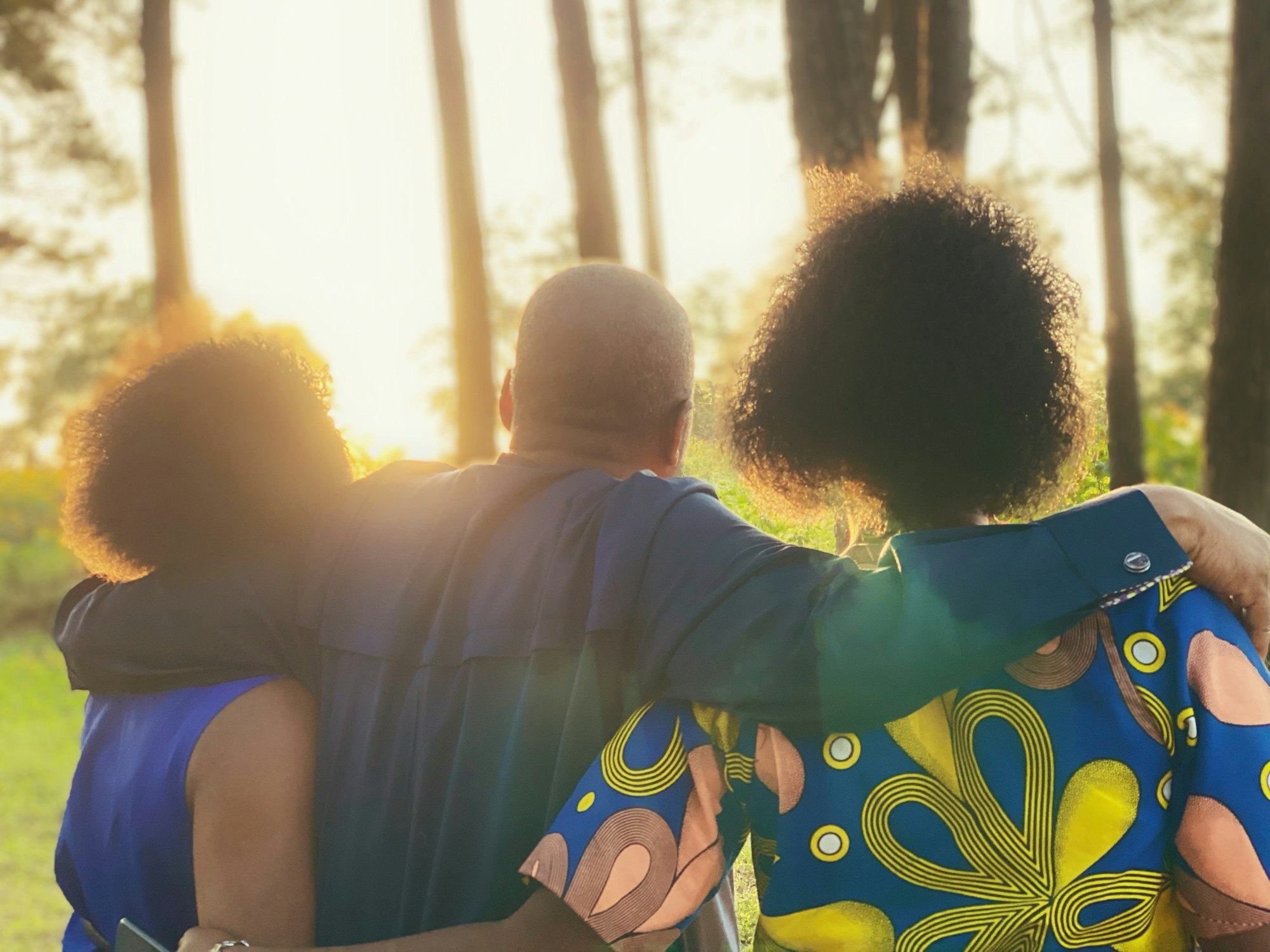 A family embracing among the trees at golden hour
