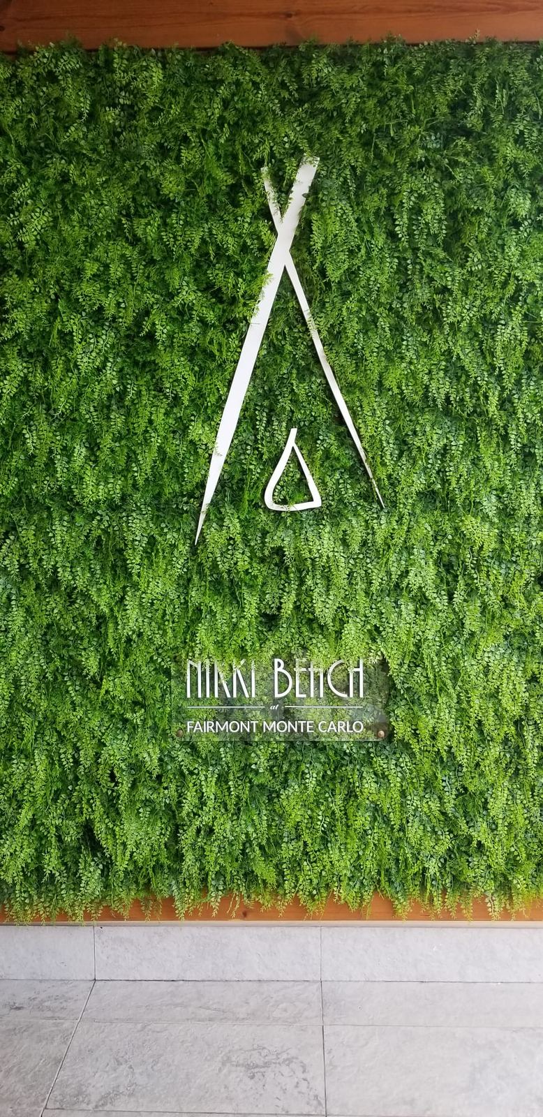 A beach club entrance with a living wall